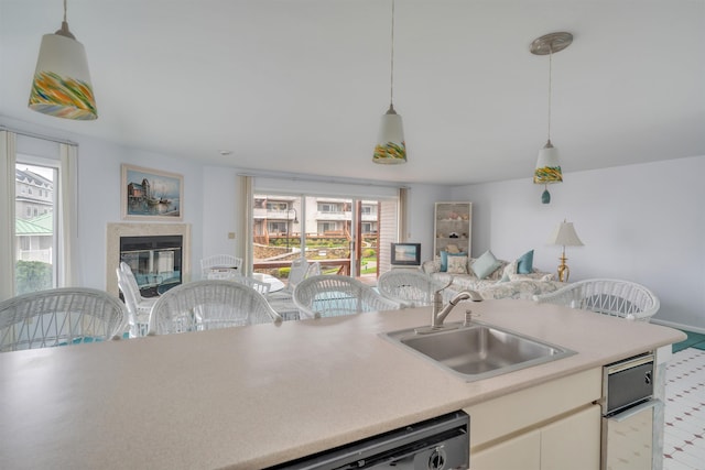 kitchen featuring a sink, a healthy amount of sunlight, open floor plan, and light countertops