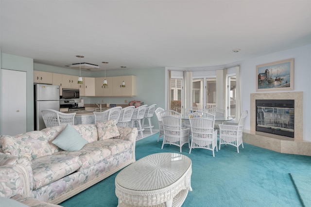 living area featuring a high end fireplace and carpet flooring
