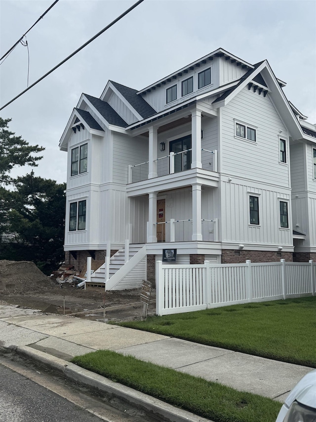 281 7th St, Avalon, NJ 08202 - view of front facade with a balcony, board and batten siding, and a fenced front yard