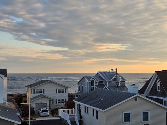 281 7th St, Avalon, NJ 08202 - back of property at dusk featuring a water view, roof with shingles, and a chimney