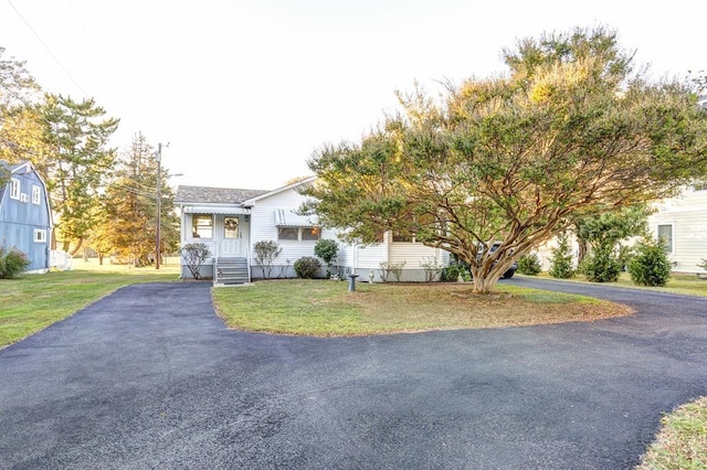 obstructed view of property featuring a front lawn