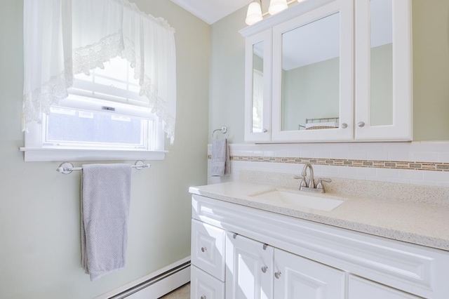 bathroom with decorative backsplash, vanity, and baseboard heating