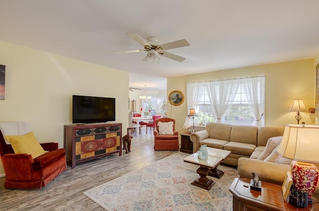 living room with light hardwood / wood-style flooring and ceiling fan with notable chandelier