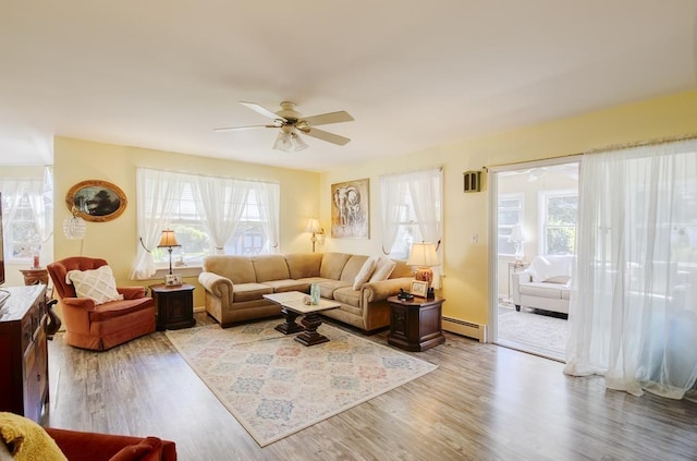 living room with hardwood / wood-style floors, a baseboard radiator, and ceiling fan