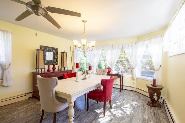 dining space with ceiling fan with notable chandelier, baseboard heating, and dark wood-type flooring