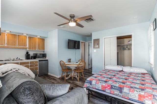 bedroom with ceiling fan, a closet, and dark wood-type flooring