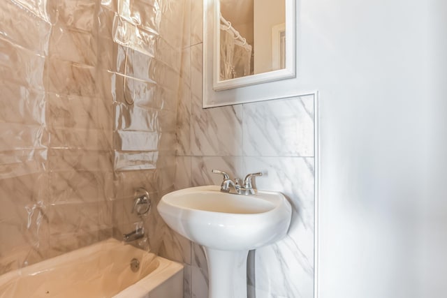 bathroom featuring tasteful backsplash, shower / bath combo with shower curtain, tile walls, and sink