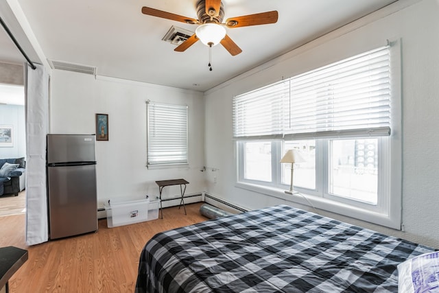 bedroom featuring stainless steel refrigerator, ceiling fan, a baseboard radiator, light hardwood / wood-style flooring, and crown molding