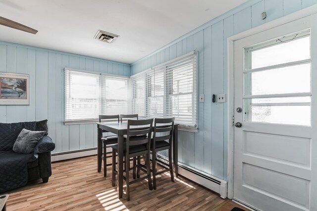 dining room featuring hardwood / wood-style floors and a baseboard heating unit