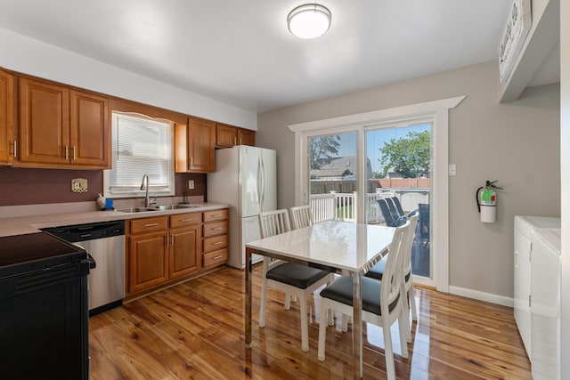 123 Broadway, Villas, NJ 08251 - kitchen featuring a sink, freestanding refrigerator, stainless steel dishwasher, light wood-style flooring, and light countertops