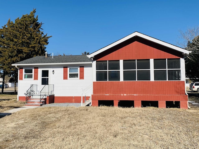 rear view of property featuring a lawn