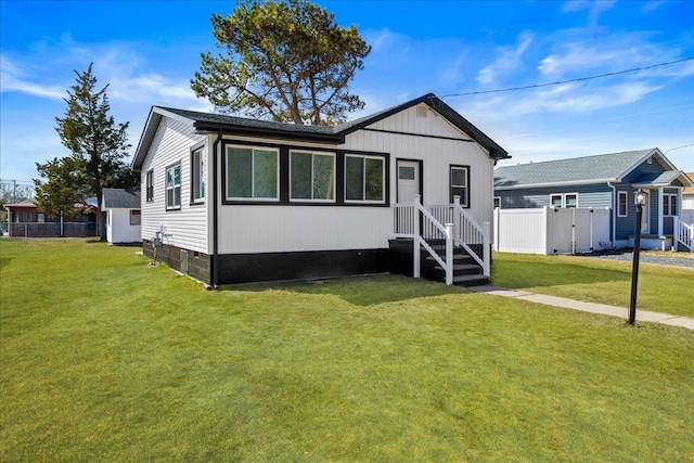 view of front of house with crawl space, a front lawn, and fence