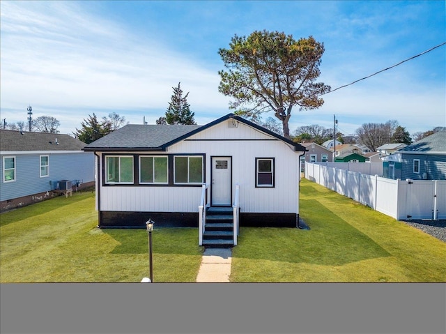 view of front of property featuring entry steps, a front yard, and fence