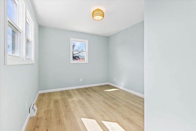 spare room featuring light wood-style floors, baseboards, and visible vents