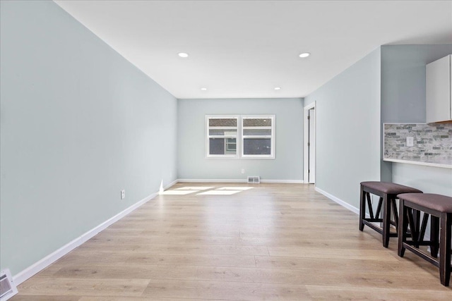 unfurnished living room with recessed lighting, visible vents, baseboards, and light wood-style flooring