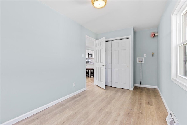 unfurnished bedroom with baseboards, visible vents, a closet, and light wood-type flooring