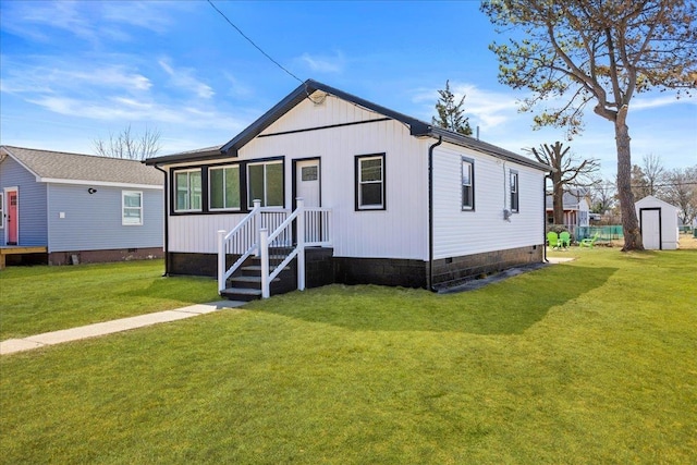 view of front of home featuring crawl space, an outbuilding, and a front lawn