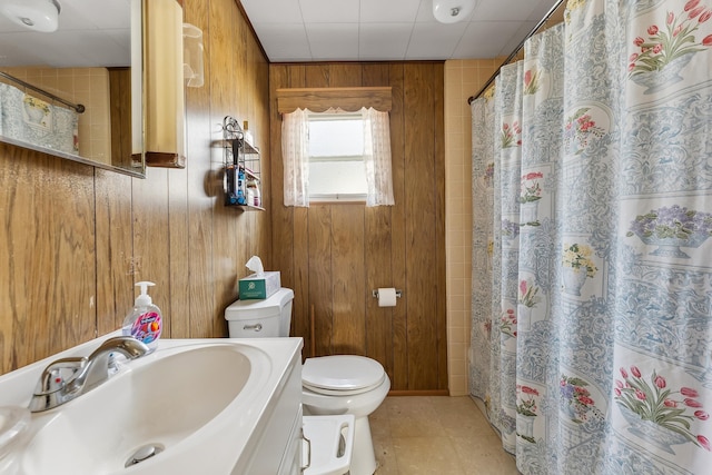 bathroom featuring wooden walls, curtained shower, toilet, and vanity