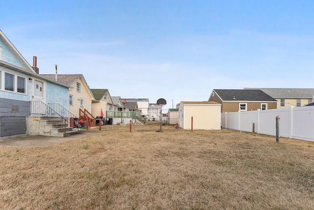 view of yard with an outbuilding, a fenced backyard, and a residential view