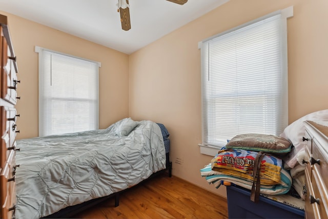 bedroom featuring multiple windows, wood finished floors, and ceiling fan