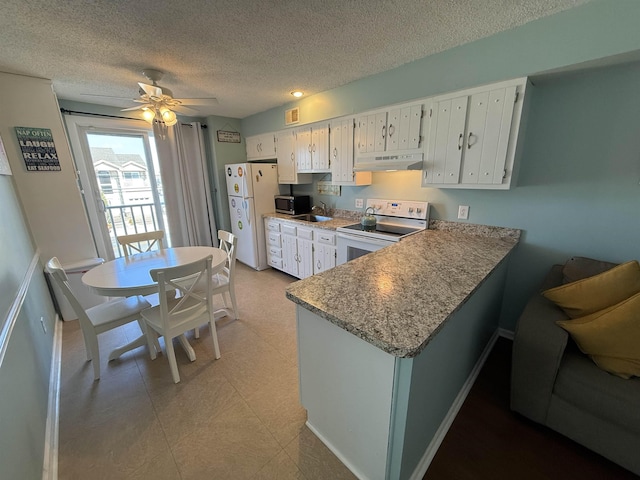 kitchen with a peninsula, white appliances, ceiling fan, under cabinet range hood, and a sink