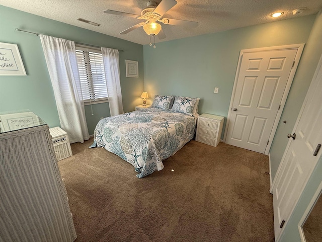 bedroom featuring a ceiling fan, carpet floors, a textured ceiling, and visible vents