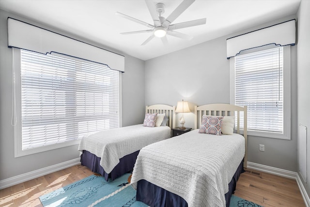 bedroom featuring ceiling fan, baseboards, and wood finished floors