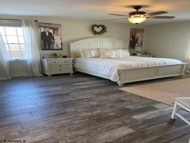 bedroom with ceiling fan, dark hardwood / wood-style flooring, and an AC wall unit