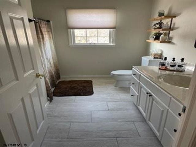 bathroom featuring vanity, tile patterned floors, and toilet