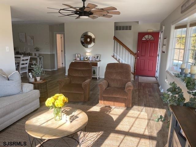 living room with dark hardwood / wood-style flooring and ceiling fan