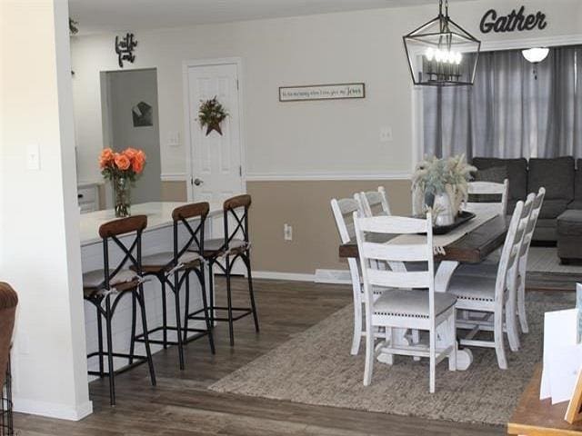 dining area with an inviting chandelier and dark hardwood / wood-style flooring