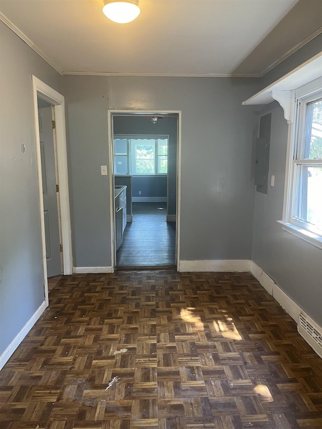 empty room with electric panel, dark parquet floors, plenty of natural light, and ornamental molding