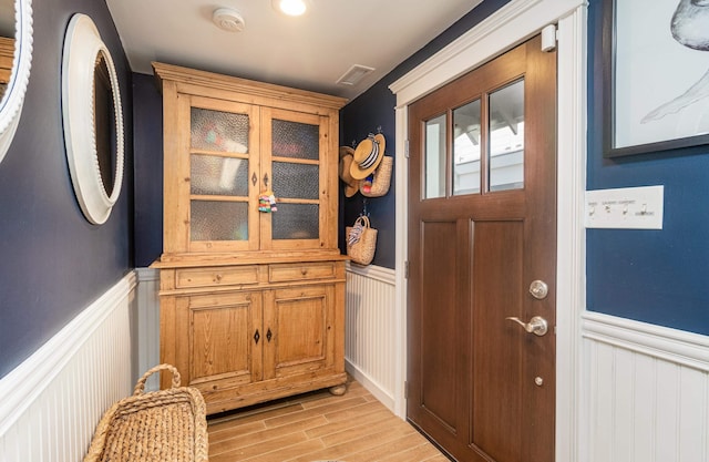 328 83rd St, Stone Harbor, NJ 08247 - doorway featuring a wainscoted wall, light wood-type flooring, and a decorative wall