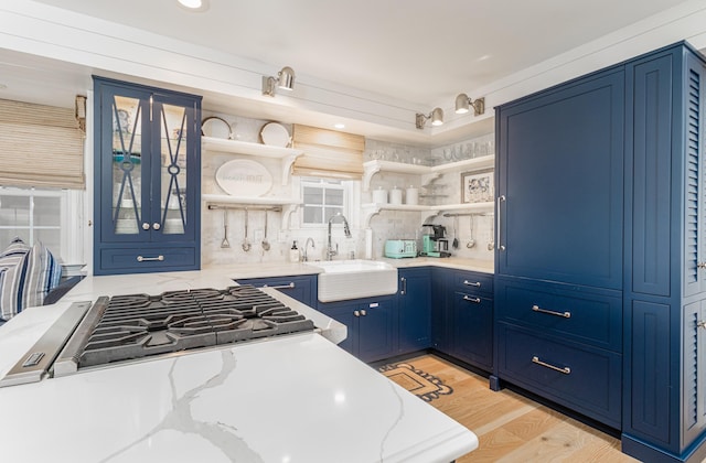 328 83rd St, Stone Harbor, NJ 08247 - kitchen featuring open shelves, blue cabinets, light stone counters, decorative backsplash, and light wood-style flooring