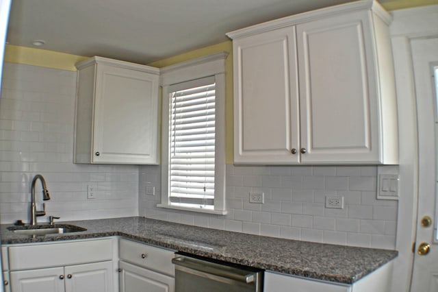 kitchen with decorative backsplash, white cabinetry, and sink