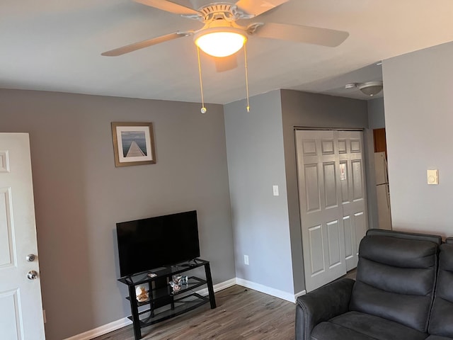 living room with ceiling fan and dark wood-type flooring