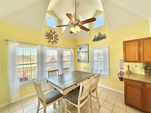 tiled dining area featuring ceiling fan and high vaulted ceiling