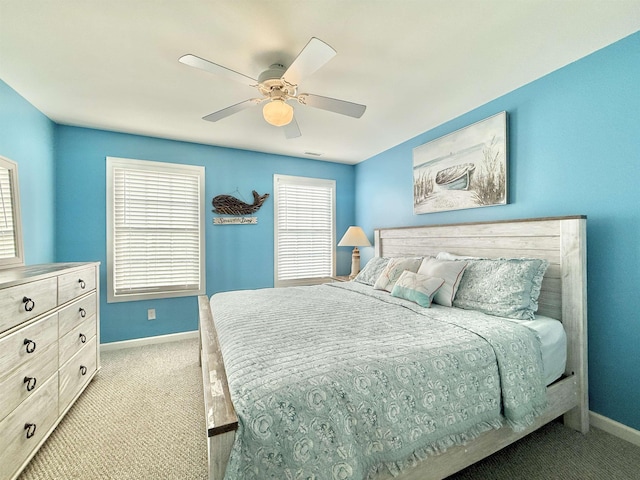 carpeted bedroom featuring ceiling fan and multiple windows