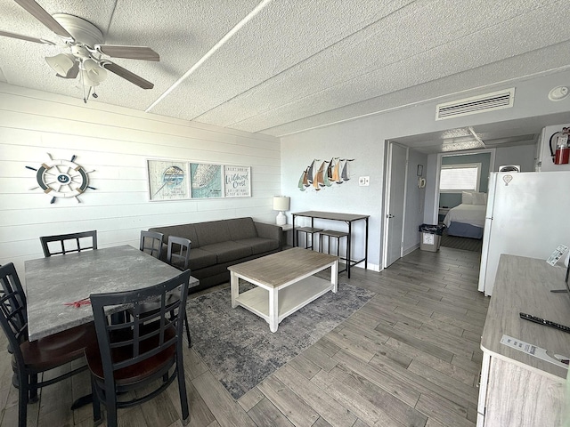 9103 Atlantic Ave Unit 413, Wildwood Crest, NJ 08260 - living area with a textured ceiling, a ceiling fan, wood finished floors, and wooden walls