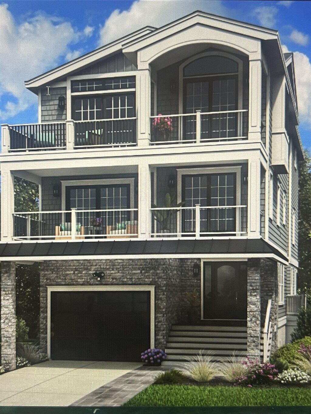 420 E 21st Ave, North Wildwood, NJ 08260 - view of front of property with a balcony, concrete driveway, an attached garage, and stone siding