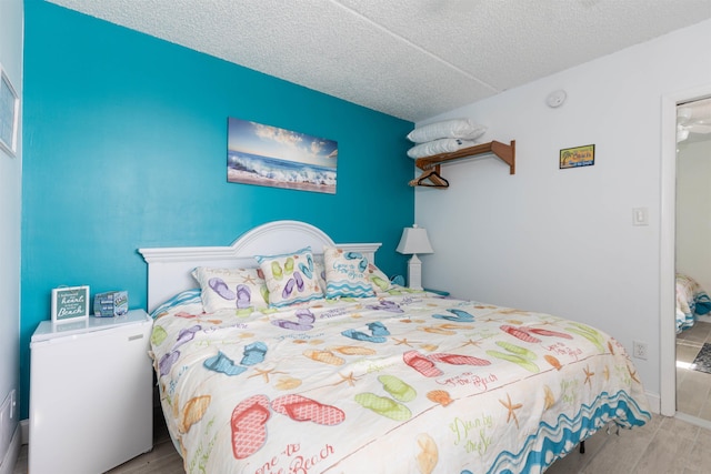 bedroom with wood finished floors and a textured ceiling