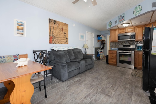 living area featuring light wood-style flooring, visible vents, and ceiling fan
