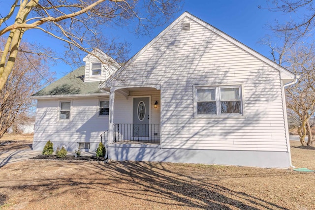 view of front of house with covered porch and a front lawn