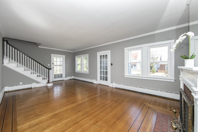 unfurnished living room with a fireplace with flush hearth, a baseboard heating unit, wood finished floors, a baseboard radiator, and stairs