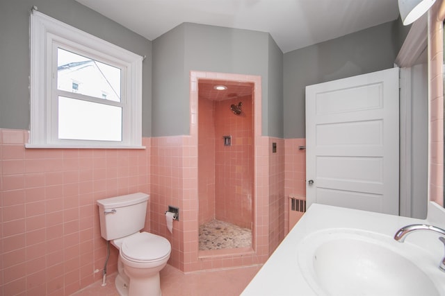bathroom with a sink, tile walls, and a stall shower