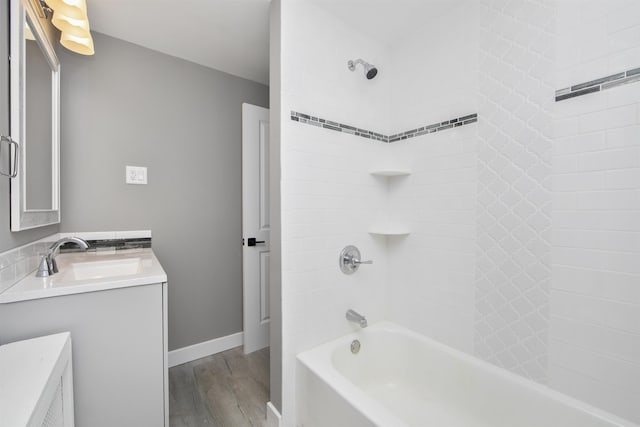 full bath with vanity, wood finished floors, tub / shower combination, and baseboards