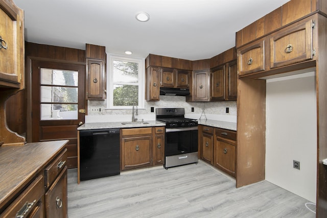 kitchen with a sink, under cabinet range hood, stainless steel gas range oven, dishwasher, and tasteful backsplash