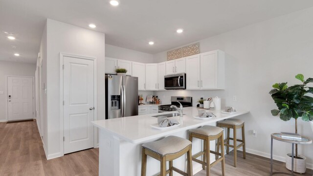 202 Bentz Ave Unit 0, Villas, NJ 08251 - kitchen featuring stainless steel appliances, a peninsula, a breakfast bar area, light wood-style floors, and white cabinets