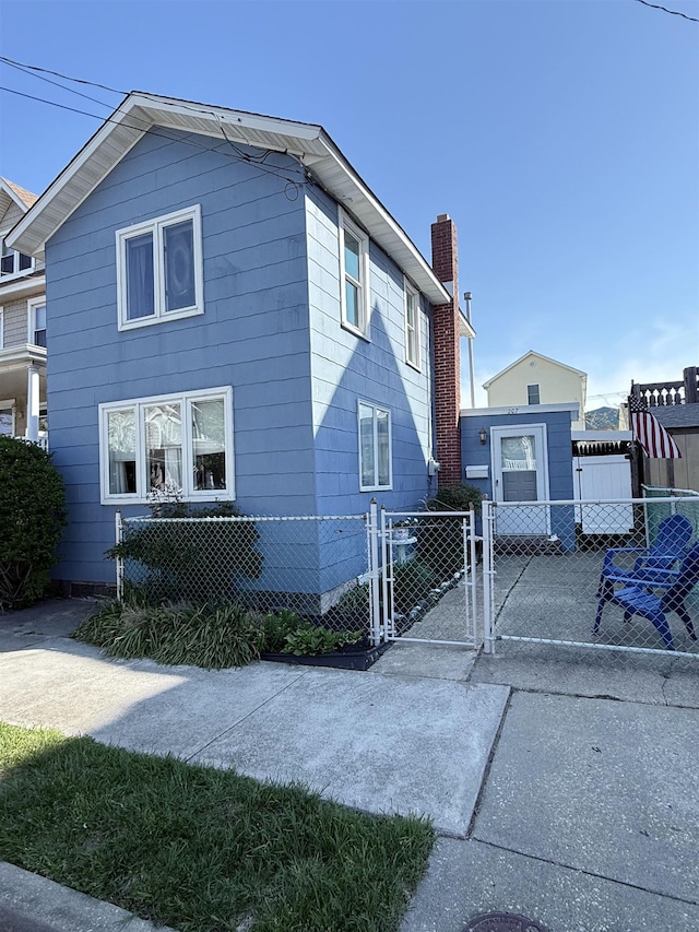 207 W Maple Ave, Wildwood, NJ 08260 - view of side of home with a gate and a chimney