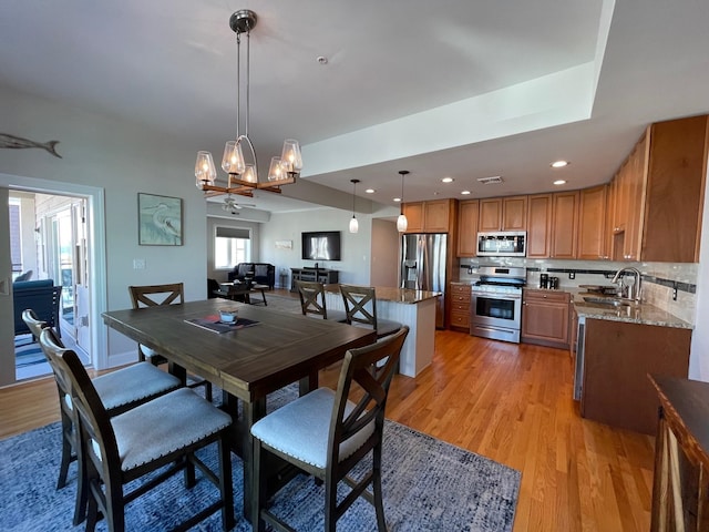 dining space featuring ceiling fan, light hardwood / wood-style floors, and sink